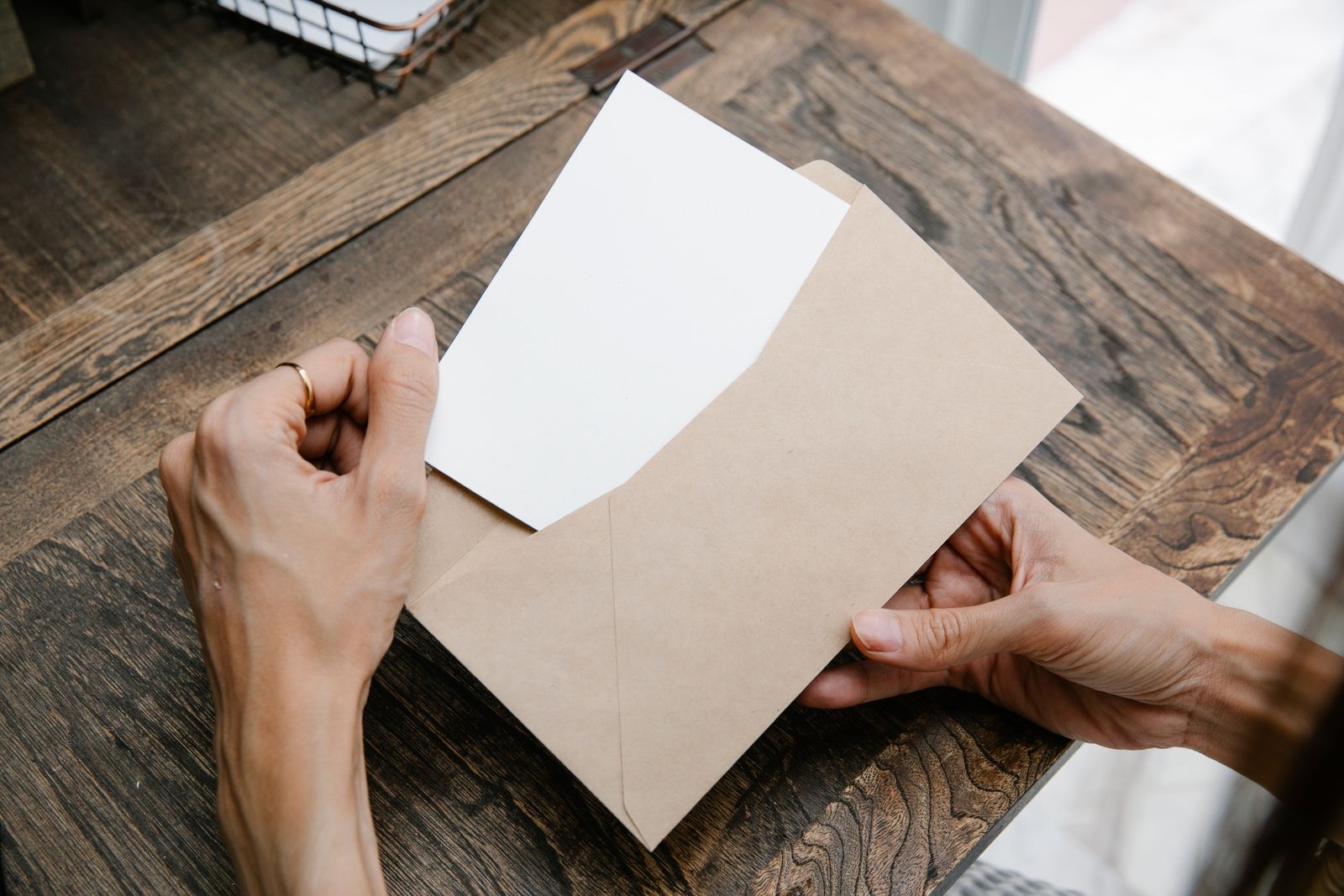 A person at a desk reading a letter, with envelopes beside them
