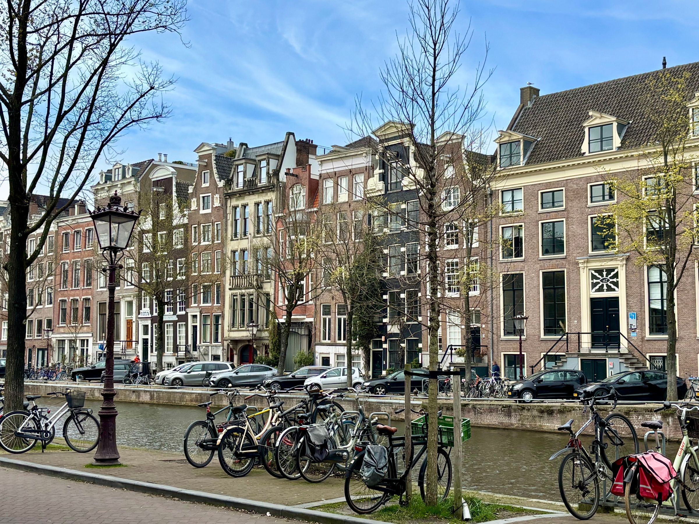 Canal houses and parked bicycles on an Amsterdam street in the morning