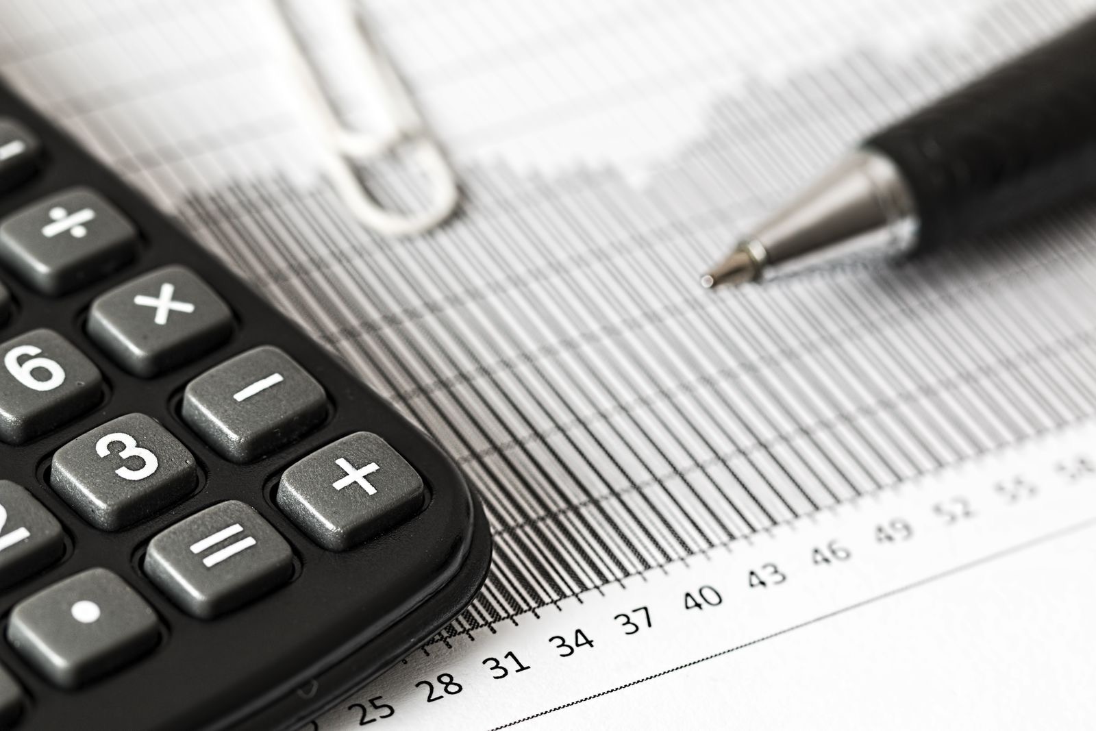 A calculator and a pen on printed figures