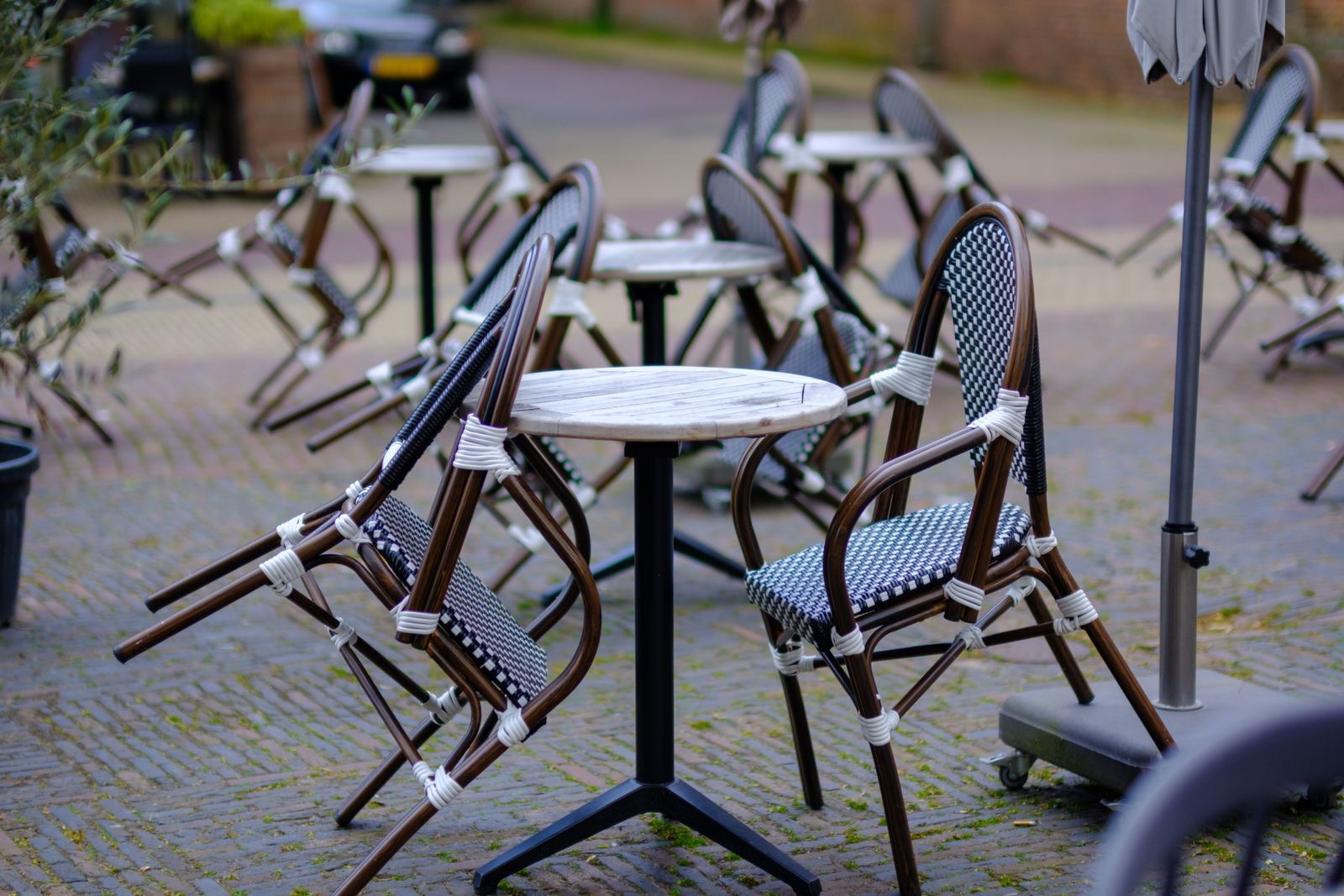An Amsterdam cafe front with an empty terrace in the morning light